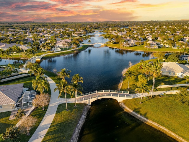 aerial view at dusk featuring a water view