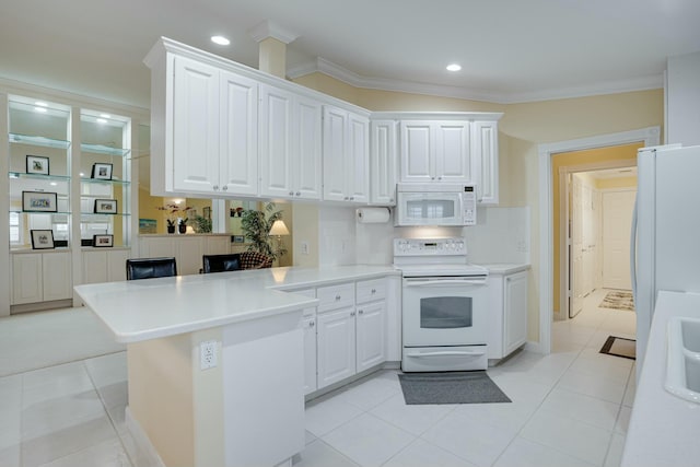 kitchen featuring white cabinetry, kitchen peninsula, crown molding, white appliances, and light tile patterned floors