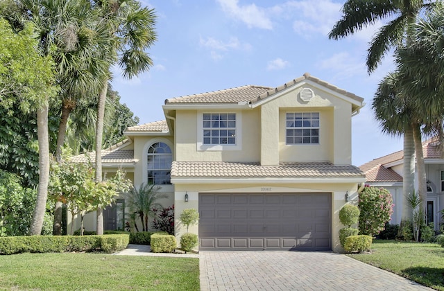 mediterranean / spanish-style house with a garage and a front lawn