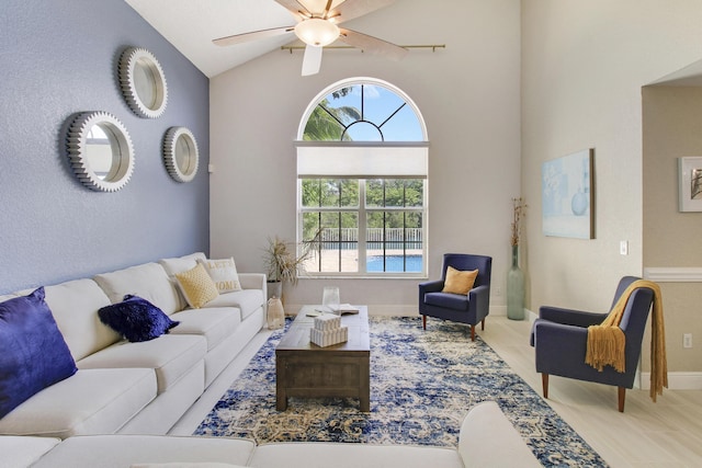 living room with ceiling fan, light hardwood / wood-style flooring, and vaulted ceiling