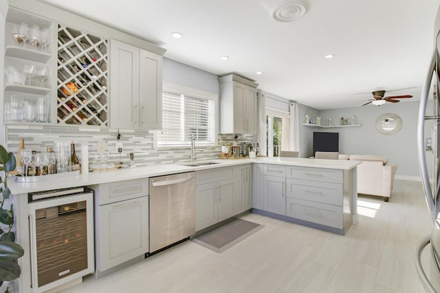 kitchen featuring sink, beverage cooler, tasteful backsplash, stainless steel dishwasher, and gray cabinets