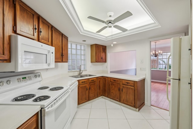 kitchen featuring sink, crown molding, a tray ceiling, white appliances, and ceiling fan with notable chandelier