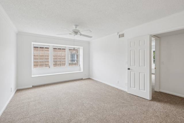 carpeted spare room with a textured ceiling, ceiling fan, and crown molding