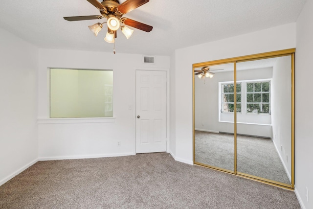 unfurnished bedroom with ceiling fan, a closet, and carpet floors