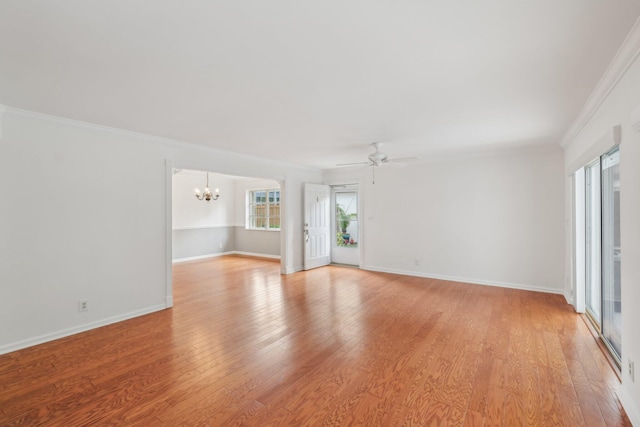 empty room featuring light wood-type flooring, ceiling fan with notable chandelier, and crown molding