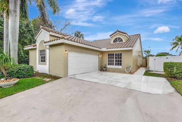 mediterranean / spanish-style home with a garage