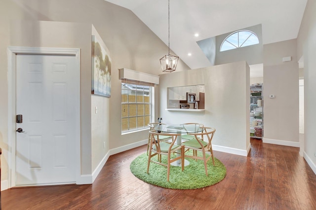 dining space featuring dark hardwood / wood-style flooring, a notable chandelier, high vaulted ceiling, and a healthy amount of sunlight