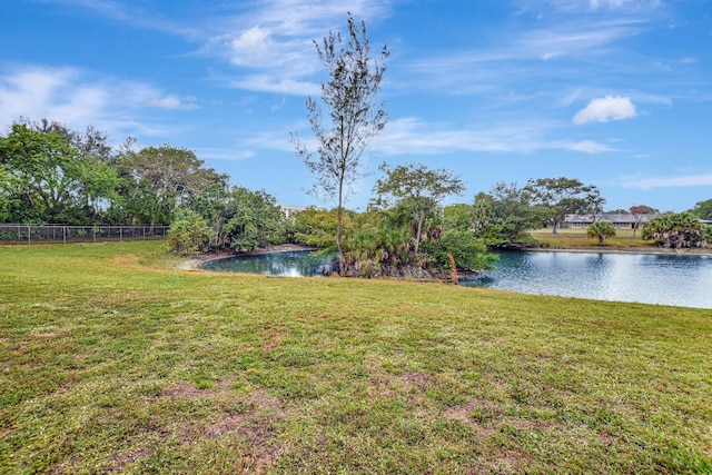 view of yard featuring a water view and fence