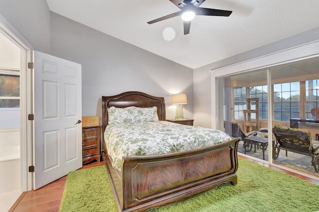 bedroom featuring ceiling fan, lofted ceiling, light hardwood / wood-style floors, and access to outside