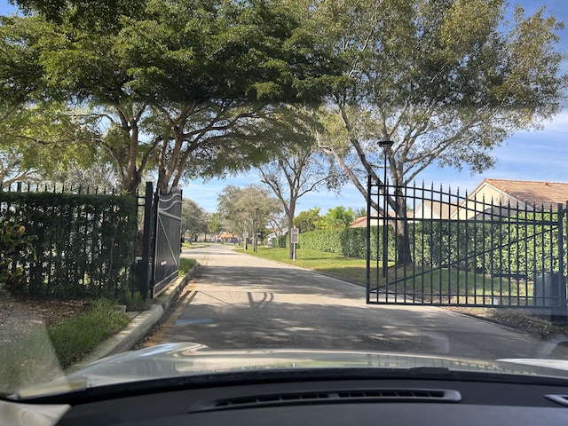 view of street featuring street lighting, a gate, and curbs