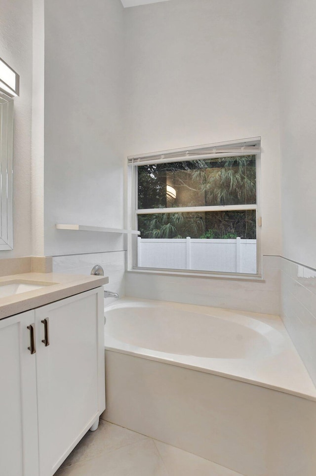 bathroom featuring tile patterned flooring, vanity, and a tub