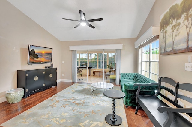 living room featuring a ceiling fan, baseboards, vaulted ceiling, and wood finished floors