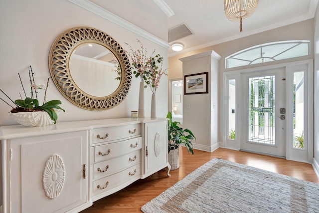 foyer featuring ornamental molding and light hardwood / wood-style flooring