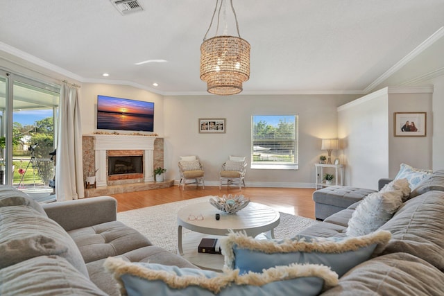 living room featuring a high end fireplace, light hardwood / wood-style floors, and a wealth of natural light