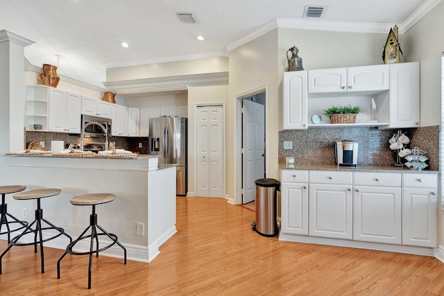 kitchen featuring stone counters, appliances with stainless steel finishes, light hardwood / wood-style floors, and white cabinetry