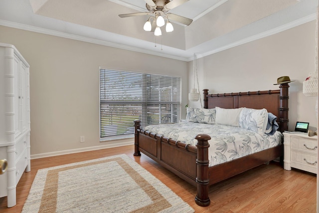 bedroom with a raised ceiling, ceiling fan, and hardwood / wood-style floors