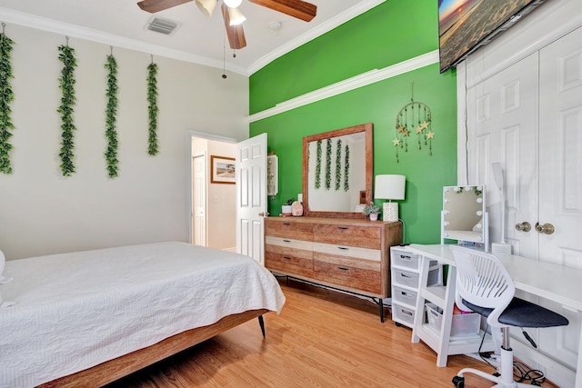 bedroom featuring ceiling fan, ornamental molding, a closet, and hardwood / wood-style flooring