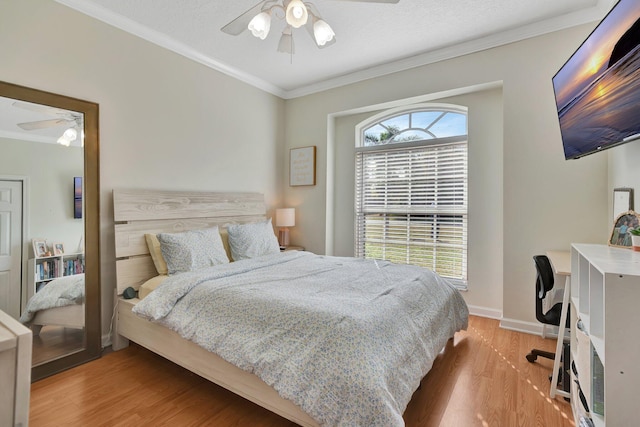 bedroom featuring ornamental molding, a textured ceiling, ceiling fan, and wood-type flooring