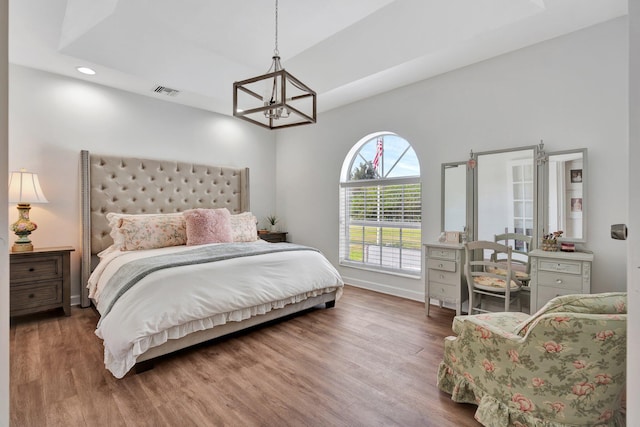 bedroom featuring a notable chandelier and dark wood-type flooring