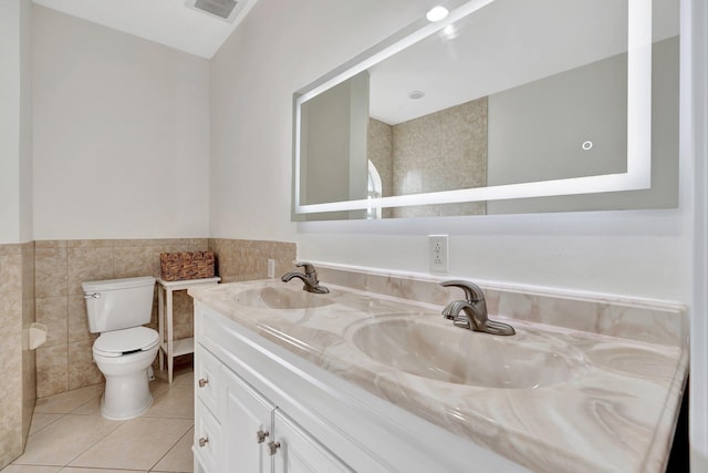 bathroom featuring tile walls, tile patterned flooring, toilet, and vanity