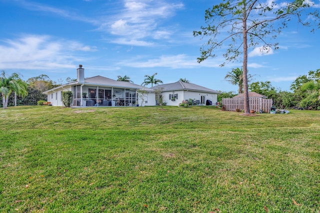 back of property featuring a lawn and a sunroom