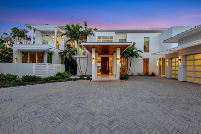 view of front of property featuring a balcony and a garage