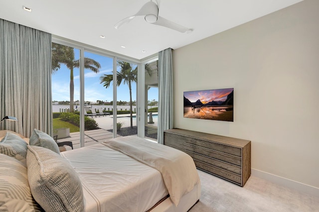 carpeted bedroom featuring ceiling fan, expansive windows, and access to outside