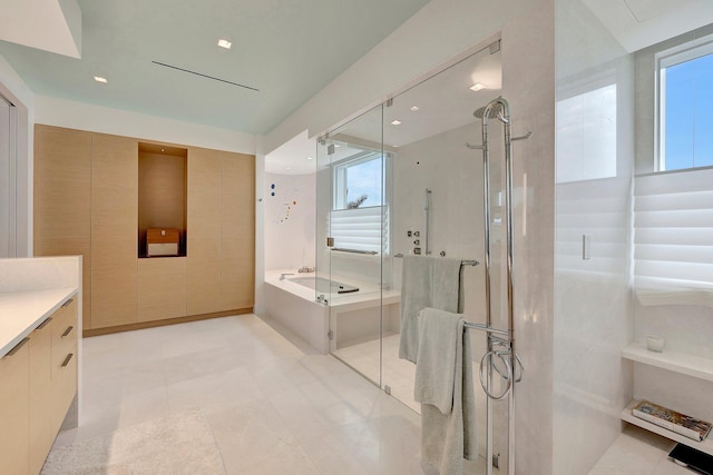 bathroom with vanity and shower with separate bathtub