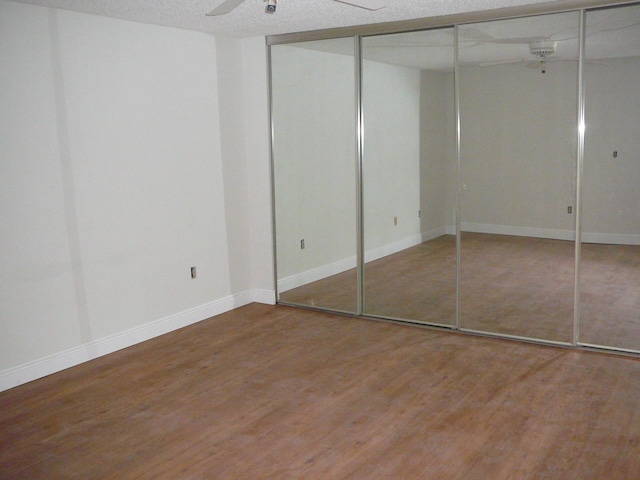 unfurnished bedroom with wood-type flooring, a textured ceiling, and ceiling fan