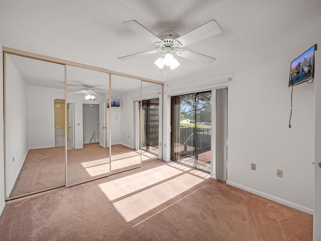 unfurnished bedroom featuring ceiling fan, a textured ceiling, access to outside, light carpet, and a closet