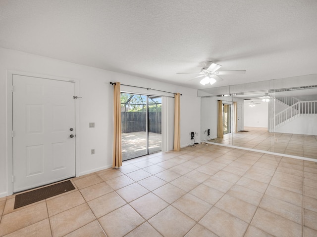 tiled spare room with ceiling fan and a textured ceiling