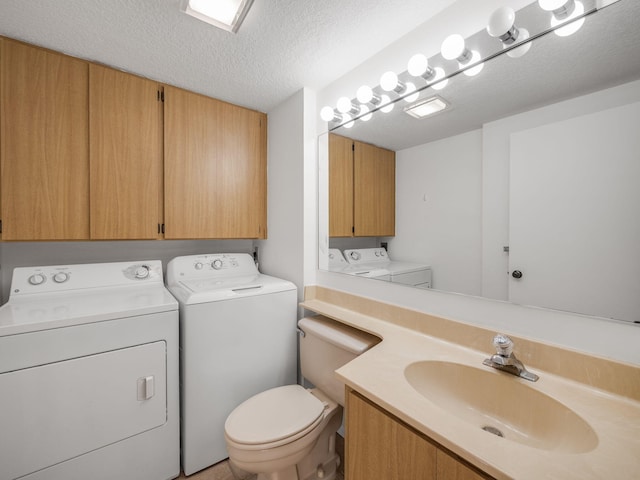 bathroom featuring sink, washer and dryer, a textured ceiling, and toilet