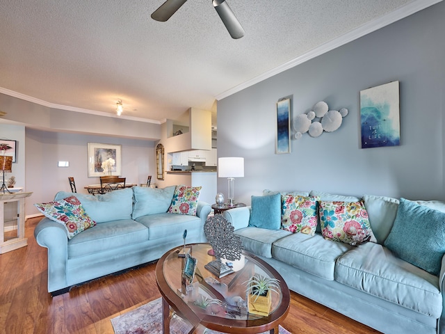 living room with hardwood / wood-style floors, a textured ceiling, ceiling fan, and ornamental molding