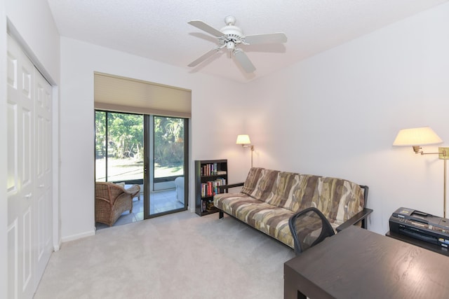 carpeted living room with a textured ceiling and ceiling fan