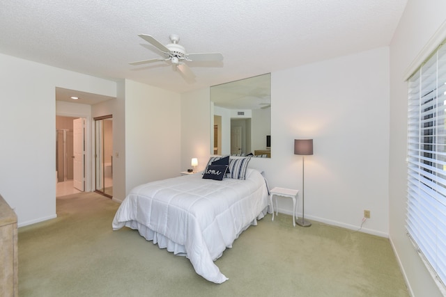 bedroom featuring light carpet, a textured ceiling, ensuite bathroom, and ceiling fan