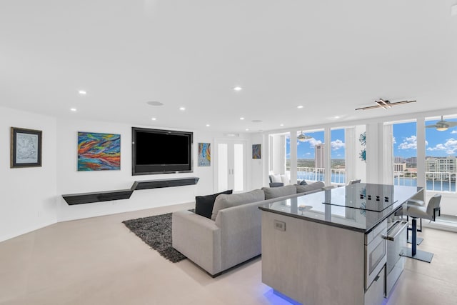 living room with ceiling fan and expansive windows