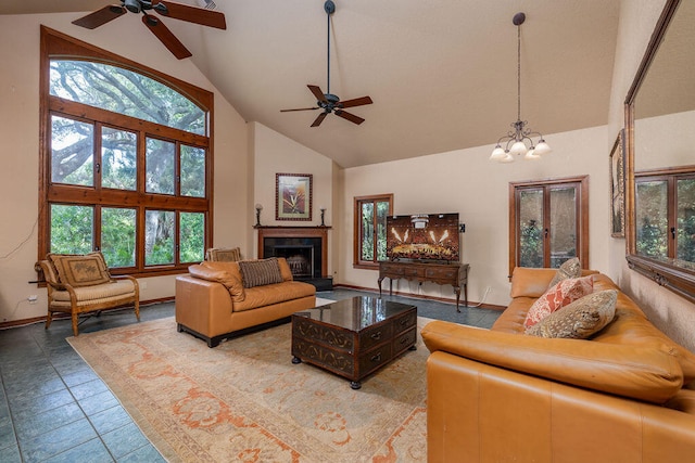 living room featuring tile patterned floors, ceiling fan with notable chandelier, high vaulted ceiling, and a tiled fireplace