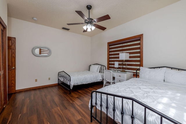 bedroom with a textured ceiling, ceiling fan, and dark hardwood / wood-style floors