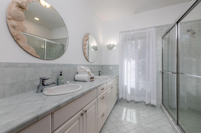 bathroom with tile patterned floors, a shower with door, and vanity