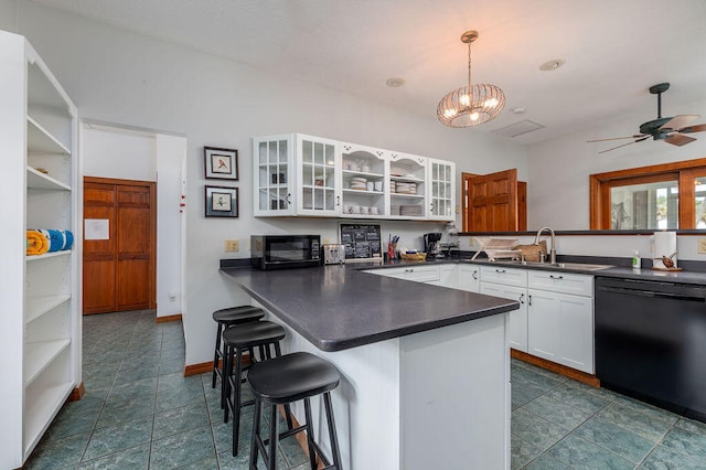 kitchen featuring kitchen peninsula, a kitchen breakfast bar, black appliances, pendant lighting, and white cabinets