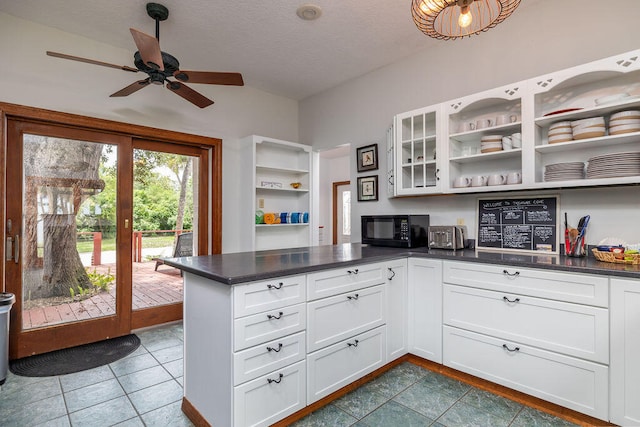 kitchen featuring white cabinets, a textured ceiling, kitchen peninsula, and tile patterned floors