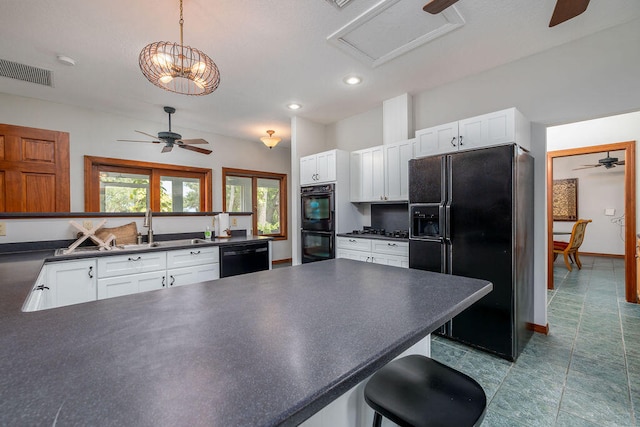 kitchen featuring sink, black appliances, white cabinets, hanging light fixtures, and a breakfast bar area