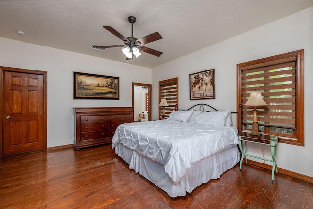 bedroom featuring ceiling fan, dark hardwood / wood-style flooring, and a textured ceiling