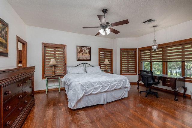 bedroom featuring ceiling fan, dark hardwood / wood-style floors, and a textured ceiling