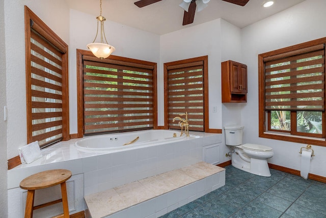 bathroom with toilet, ceiling fan, and tiled tub