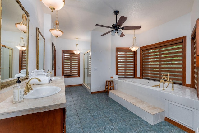 bathroom with ceiling fan, vanity, and shower with separate bathtub