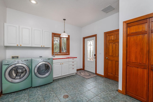 laundry area with cabinets, sink, and washing machine and dryer