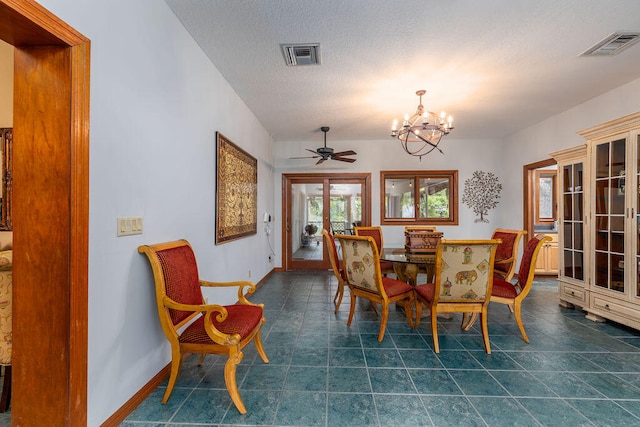 dining area with a textured ceiling, french doors, and ceiling fan with notable chandelier