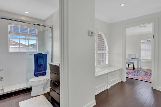 bathroom featuring hardwood / wood-style floors, vanity, a shower with door, and toilet