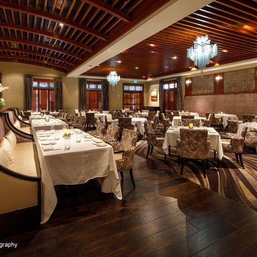 dining space featuring wood-type flooring, vaulted ceiling, a notable chandelier, and brick ceiling